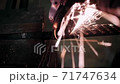Grinding metal with a grinder. The blacksmith works with metal. Blacksmithing craft. 71747634