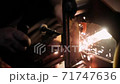 Grinding metal with a grinder. The blacksmith works with metal. Blacksmithing craft. 71747636