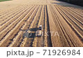 Tractor carrying a trailer with wheat grain from the field to the warehouse, harvesting wheat in the field 71926984