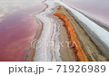 Spit on a pink lake where salt deposits are deposited. Salt pink lake. Recreation and tourism. 71926989
