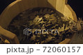 Close up view of oak broom in wooden tub in bath with hot steam from water on black background in slowmotion 72060157