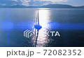 Boating in open sea with beautiful crystal wather and islands on the horizon. 72082352