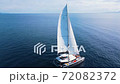 Beautiful white sailboat in open water on sunny weather, aerial view. 72082372