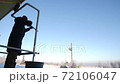 Silhouette of a man with a gun on the background of a shooting range. A man shoots a gun at Skeet, targets. Shooting practice. Winter. 72106047