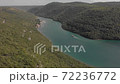 Motorboat floats in narrow sea bay between woody hills. Aerial of Lim bay, Rovinj, Croatia 72236772