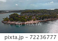 Flying around rocky cape on the shore of Adriatic Sea. Green forest and rocks of Istria, Croatia 72236777