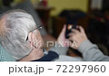 Elderly retired man in the 80s leaning on the sofa and using smartphone for news . Slow motion 72297960