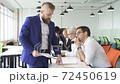 Male director give directions to employees in the office. 72450619