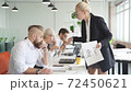 Furious female director dissatisfied with work, she yells at emplyees holding papers documents in hands. 72450621