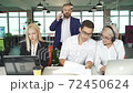 Young team concentrated on work on laptop while director near them 72450624