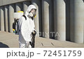 Side view on man in hazard wearing with equipment for disinfection. 72451759