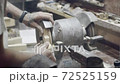 Wood surface grinding machine. Action. Hands of Professional carpenter grinds edges of wooden piece on belt grinder. Industrial woodworking grinding machine 72525159
