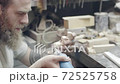 Woodworking. Professional carpenter shaping and designing a wooden workpiece with a manual engraver 72525758