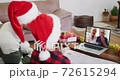 Caucasian man with son wearing santa hats on laptop video chat during christmas at home 72615294