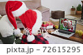 Caucasian man with son wearing santa hats on laptop video chat during christmas at home 72615295