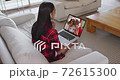 Mixed race woman on laptop video chat wearing wireless earphones during christmas at home 72615300