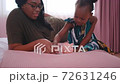 African American mother teach her daughter or little girl to collect money by put in piggy bank 72631246
