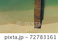 waves crashing onto dock on tropical beach 4k aerial drone 72783161