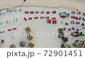 Top aerial view of sandy beach, straw umbrellas and roofs of small cabins at resort, tourists enjoy the fresh evening in armchairs. GILI AIR Air island, Indonesia 72901451