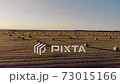 Aerial drone shot of straw bales (dry grass) on farmland. Wheat field after harvest at sunset. Natural rural landscape. Summer field with rolls of hay at sunset, countryside. 73015166