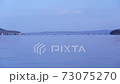穏やかな海と青空に架かる能登島大橋 73075270