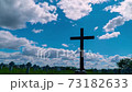 Cross on the cemetery. Time lapse clouds flowing past 73182633