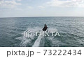 a young guy rides a jet ski on the sea at high speed 73222434