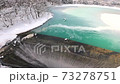 厳寒のダム湖から流れ落ちる水 73278751