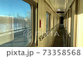 In the corridor of the compartment car of the train in motion, flashing winter landscape outside the 73358568