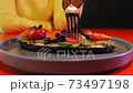 Woman eating salad with fork 73497198