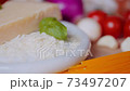 Grated cheese in a saucer on the table 73497207