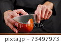 Chef cuts a large tomato 73497973