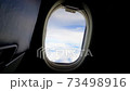 sky view with white clouds from window of passenger seat in cabin on commercial airplane. Transportation and travel concept. 73498916