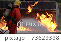 Slow motion: Firefighter using Chemical foam fire extinguisher to fighting with the fire flame from oil tanker truck accident. Firefighter safety disaster accident and public service concept. 73629398