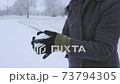 Woman holding and rolling snowball close up 73794305