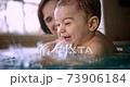 Happy baby splashing water playing with mom in indoor pool 73906184