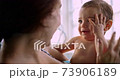 Baby laughing playing with mother touching face in indoor pool 73906189