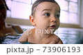 Happy baby swimming with mother in indoor pool 73906193