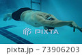 Adaptive amputee athlete swimming underwater in indoor pool 73906203