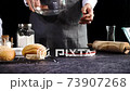 Professional man chef baker wear grey apron measure the flour into a bowl on the electronic scales 73907268