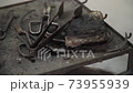 Rusty old metal tools like scissors and pincers lying on metal table. Traditional rustic glassblowing instruments reflecting light and fire in a glass-making workshop in Murano, Venice. 4K background. 73955939