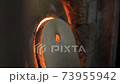 An old glass blowing furnace with hot flames leaking behind the stone covers. A rustic fireplace burning gas to heat molten glass in a traditional factory in Murano, Venice. Slow-motion background 4K. 73955942