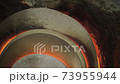 An old glass blowing furnace with hot flames leaking behind the stone covers. A rustic fireplace burning gas to heat molten glass in a traditional factory in Murano, Venice. Slow-motion background 4K. 73955944