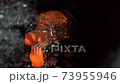 Abstract 4K background of melted glass glowing in hot red and orange. Molten droppings from the glassblowing process in Murano, Venice. Beautiful mysterious high-contrast backdrop. 73955946