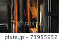 An old glass blowing furnace with hot flames as cool industrial fire background. A rustic fireplace burning gas to heat molten glass in a traditional factory in Murano, Venice. Slow-motion 4K. 73955952