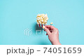 Eating popcorn stop motion video. Popcorn box top view on a blue background. 74051659