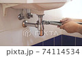 plumber fixes  sink siphon in bathroom by adjustable plumber wrench  74114534