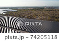 Solar panel station with reflection of sun and river on background. ECO system. Aerial view of solar station 74205118