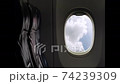 Cloudscape. Blue sky puffy fluffy white clouds time lapse. View from window of passenger seat in cabin on commercial airplane. Transportation and travel concept. Airplane flight. 74239309