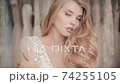 Sensual woman in wedding dress in bridal salon. Portrait of sensitive model touch her body in gown 74255105